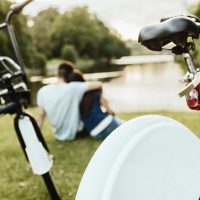 Couple sitting in park with bicycles in foreground